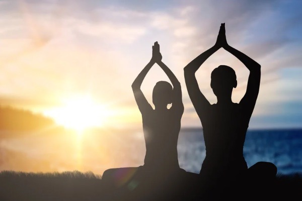 Zwei Yogis Praktizieren Kundalini Yoga in der Abendsonne